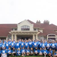 Large group photo of volunteers in front of Alumni House